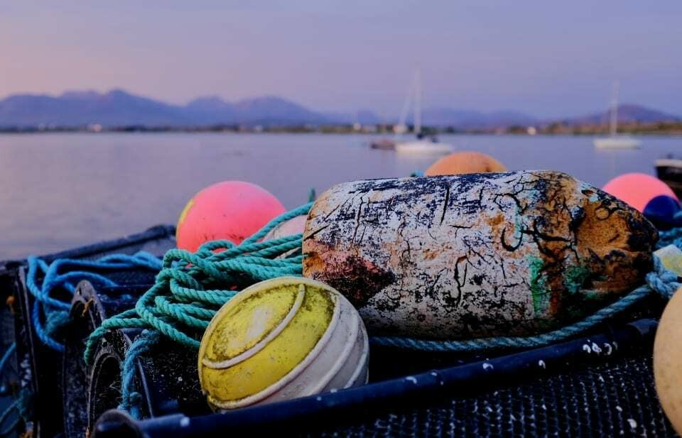 Bright fishing floats and nets as the sun sets over Roundstone.