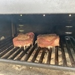 Pork chops getting grilled. 