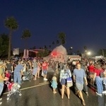 Panoramic photo of fire truck spraying water at holiday festival. 