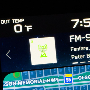 Car infotainment display showing OUT TEMP 0 °F on the left, time 7:53 in the upper right, FM-99.5 radio tuned to a classical station with a green Radio logo, displaying \