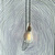 Auto-generated description: A vintage-style light bulb hangs against a wall with concentric black lines creating an optical illusion.