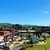 Auto-generated description: A vibrant town square in Johnson City, Tennessee features a bustling market, lush greenery, and scenic mountain views under a clear blue sky.
