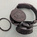 Auto-generated description: A pair of black headphones with one ear cup detached and its cover removed sits on a light-colored surface.
