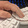 A hand is resting on keys that are curved downward on a keyboard with white keycaps.