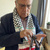 Yousef Qandeel wearing glasses and a Palestinian scarf (keffiyeh) is holding a bunch of old keys.