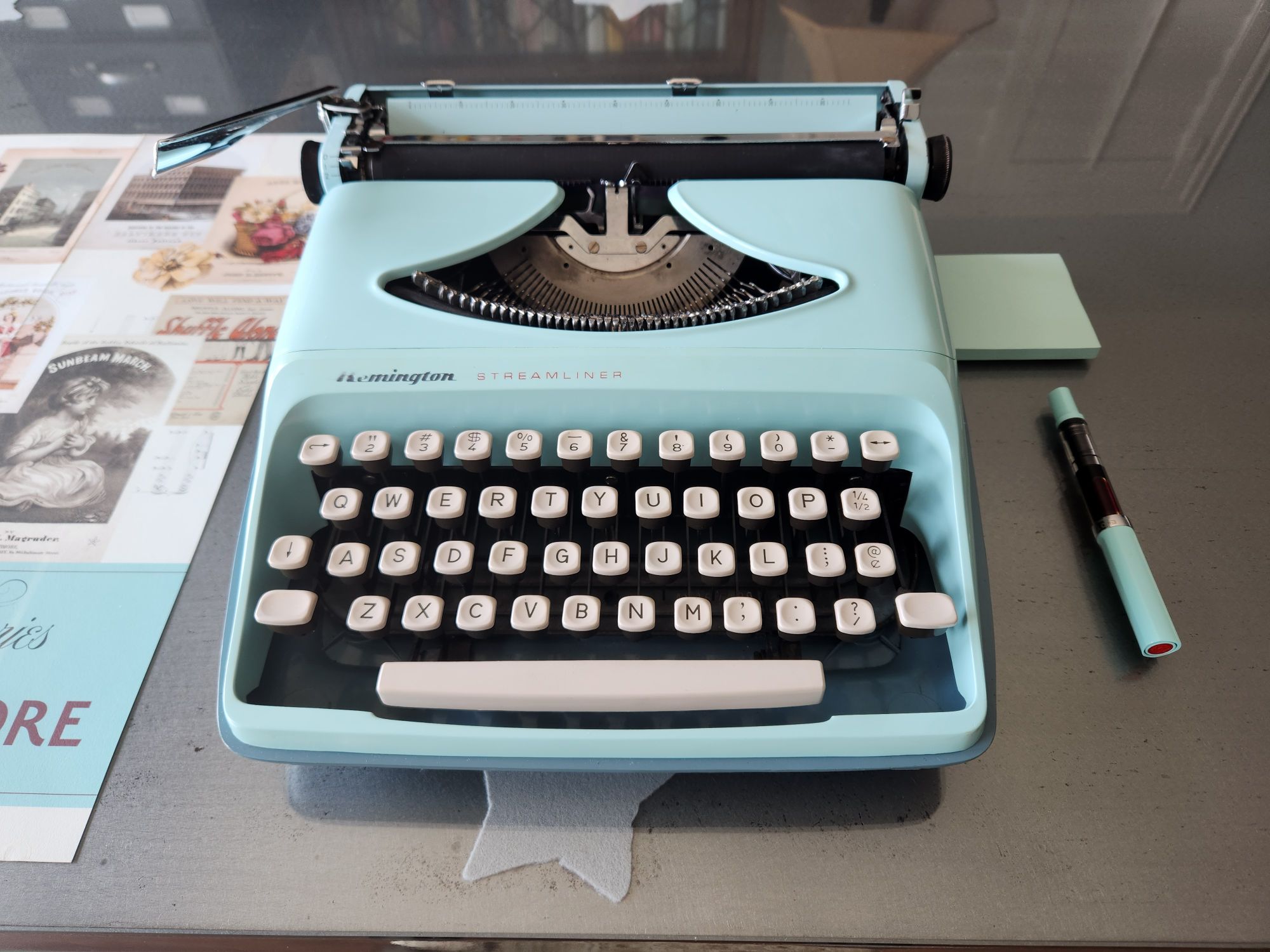 Fontal view of a mint blue Remington Streamliner sitting on a glass table top.