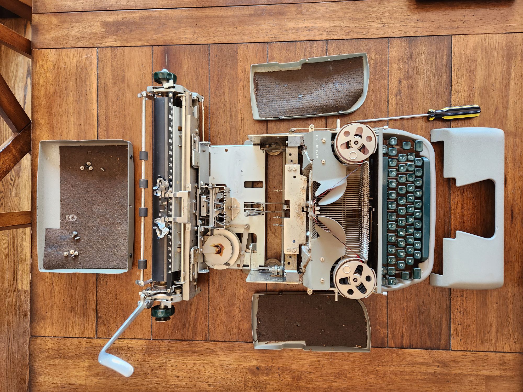 Remington Standard viewed from above with all it's body panels removed along with several screws removed to allow the Fold-A-Matic functionality to open the rear/carriage of the unit for servicing.