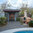 Jamdown villa pool area with wooden door in stone arch, coal-fired grill and paved patio