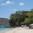 Rocky bluff with building above Princess Margaret Beach, pier and Jack's Beach Bar area visible