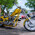 Yellow custom chopper motorcycle with chrome wheels and flame decals parked on a town street