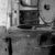A rusty, industrial Whirlwind machine with an open lid, surrounded by pipes in a weathered room