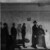 Black and white mural of early 20th-century immigrants standing in a queue on a weathered interior wall