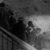 Mural of men in early 20th-century suits and hats on a wall next to a staircase