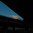 Silhouetted elevated motorway bridges framing a blue dusk sky with clouds, city buildings visible below