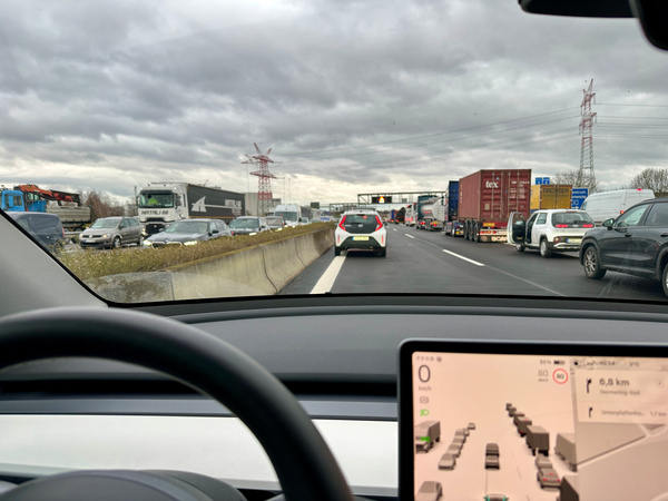 Die A99 mit dichtem Verkehr, die aus der Perspektive eines Tesla Model Y mit einem digitalen Display fotografiert wurde.