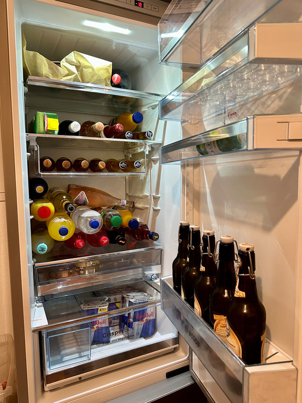 Ein Kühlschrank ist voll mit verschiedenen Getränken, darunter Flaschen und Dosen.