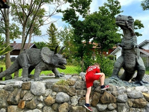 Sohn beklettert die Dinosaurier am Urweltmuseum