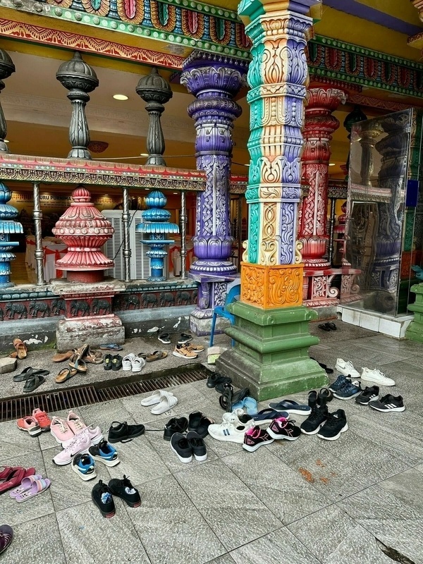 Innenraum der Batu Caves mit hohen Felswänden und Tempelanlage.