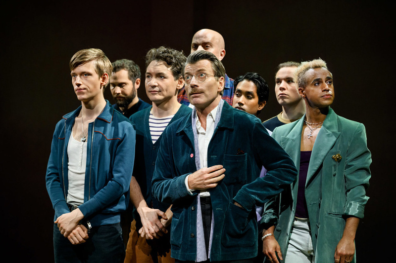 Auto-generated description: A group of people is standing closely together, with some looking forward attentively.