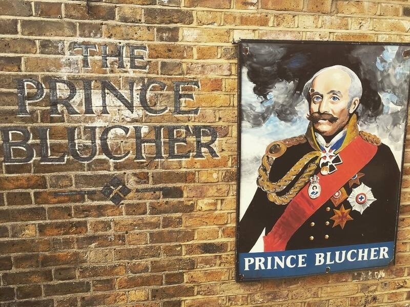A portrait of Prince Blucher in military attire is displayed on a brick wall next to the text THE PRINCE BLUCHER.
