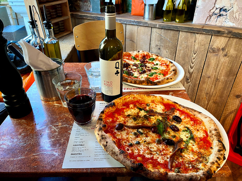 Two whole pizzas and a bottle of red wine