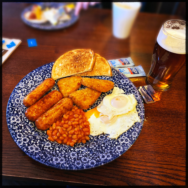 Plate of cooked breakfast and a pint of beer