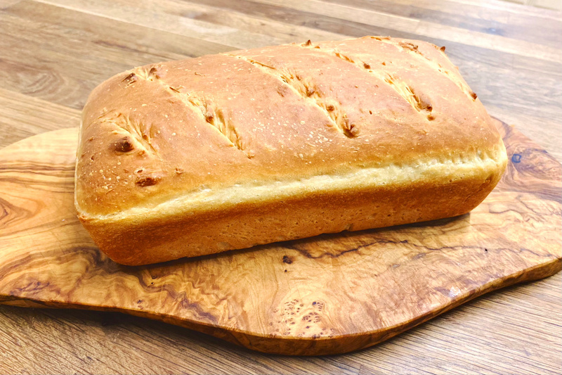 Rectangular loaf of bread on a wooden chopping board