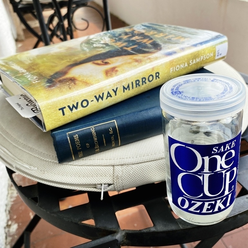 Two books and a glass of sake on an outdoor chair