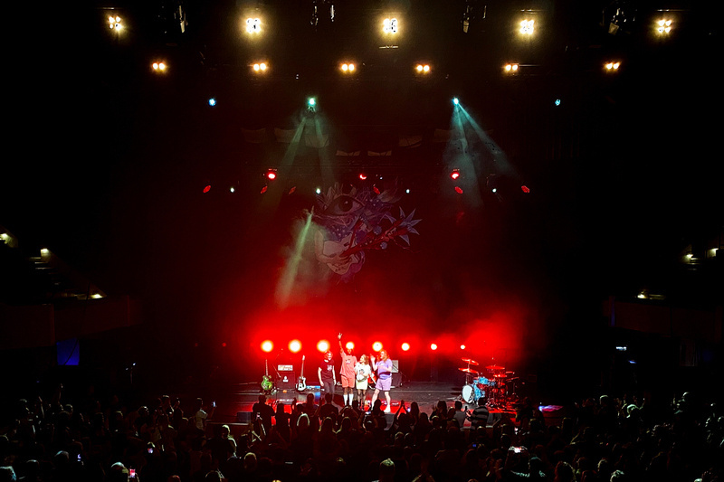 Band on stage at end of a gig, waving to audience