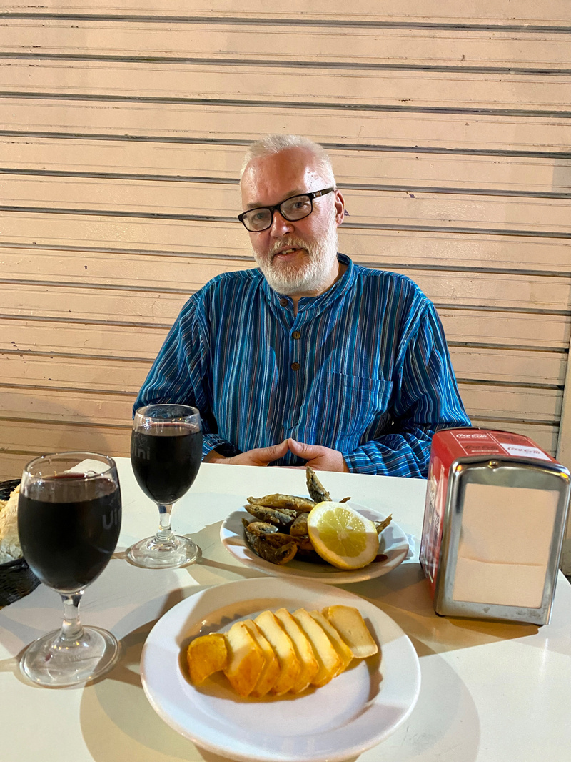 Man seated at table of food and drink