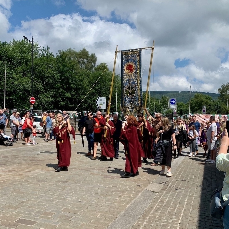 Procession of people in Druidic robes through a town centre