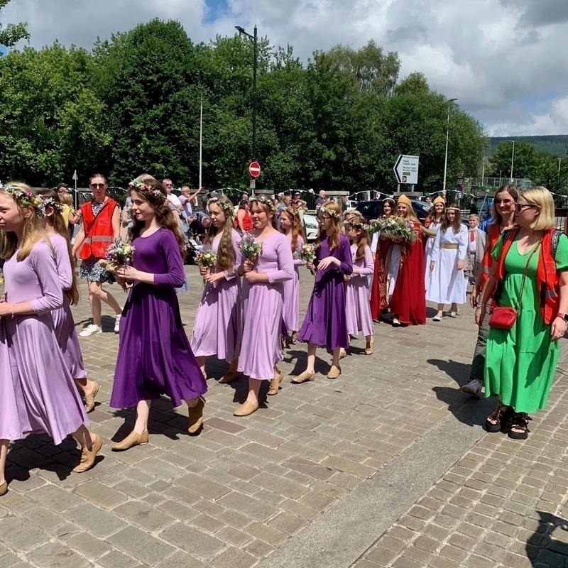 Procession of people in Druidic robes through a town centre