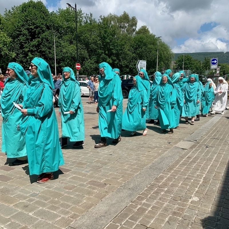 Procession of people in Druidic robes through a town centre