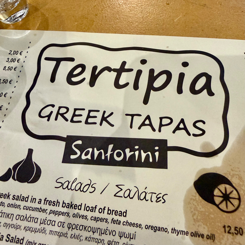 A menu features Tertipia Greek Tapas with a specific mention of Santorini and a section for salads.
